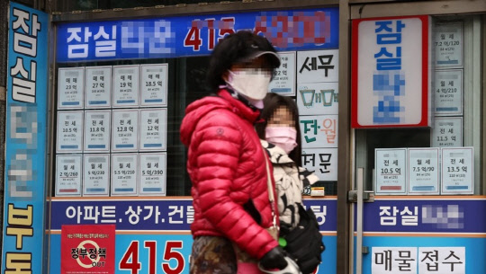 시민들이 부동산 매물정보가 붙어있는 부동산공인중개업소 게시판 앞을 지나가고 있다. <연합뉴스>